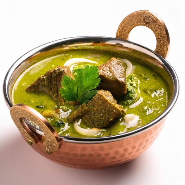 Maharaja Indian Cuisine's Palak Gosht, a vibrant green spinach and lamb curry, served in a copper karahi.