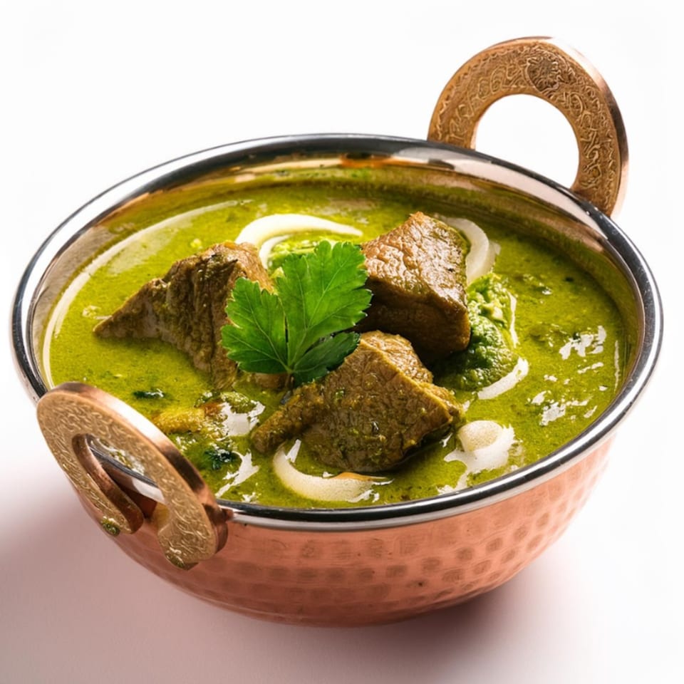 Maharaja Indian Cuisine's Palak Gosht, a vibrant green spinach and lamb curry, served in a copper karahi.